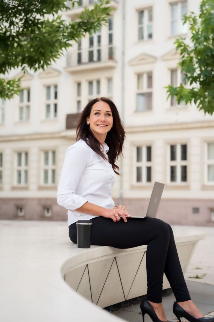 Business Frau sitzend weiße Bluse Laptop Businessportrait