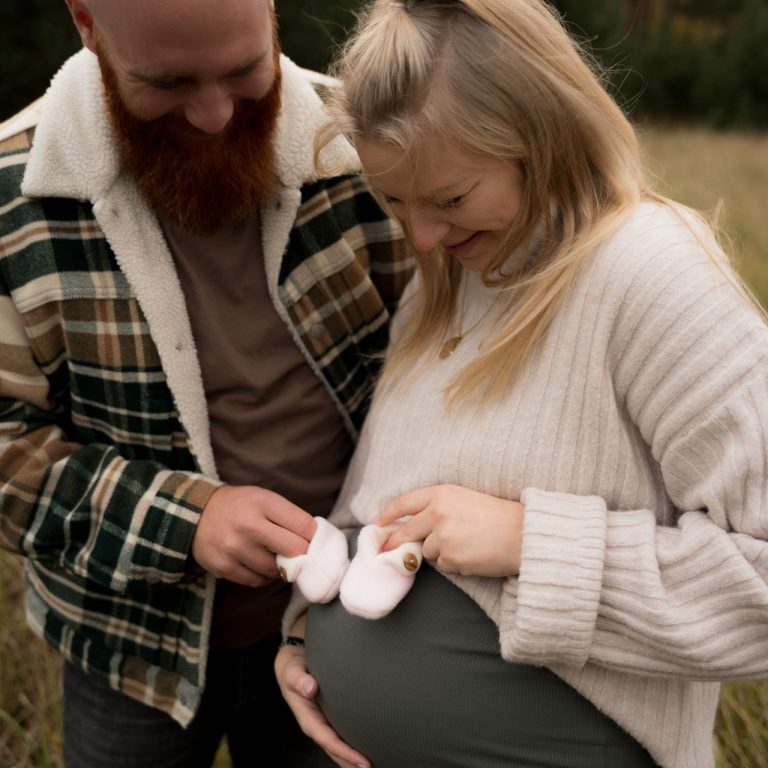 Babybauchshooting Mann und Frau Babysöckchen