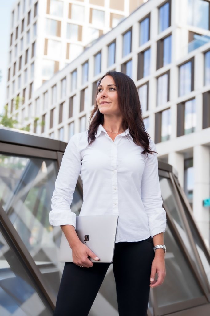 Business Frau weiße Bluse stehend Bürogebäude modern 