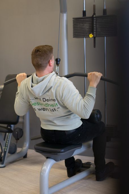 Mann trainiert am Kabelzuggerät in einem Fitnessstudio.